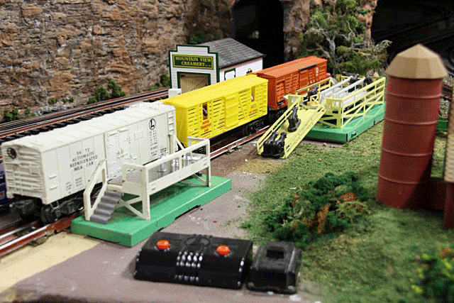No toy train layout would be complete without Lionel's operating milk and cattle cars. They are here for all the "kids" to see them work.